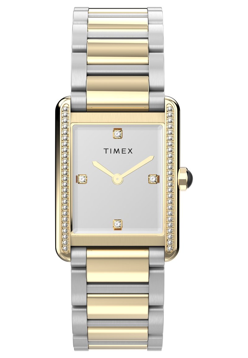 Montre rectangulaire en acier inoxydable et ton or avec un cadran blanc, quatre repères ressemblant à des diamants et une lunette décorative en pierres précieuses.