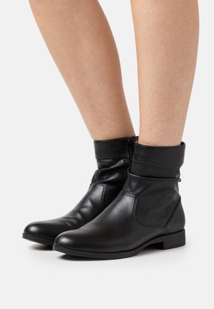 Black ankle boots made of smooth leather, featuring a folded cuff, a sleek design, and a low block heel for stability.