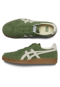 Zelené semišové tenisky s bílými koženými detaily, kulatá špička, plochá gumová podešev, perforované detaily na svršku a klasické logo na jazyku.