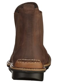 Bottine en cuir marron avec des panneaux latéraux élastiques, des détails cousus, un accent en cuir marron clair contrastant au talon et une semelle noire.