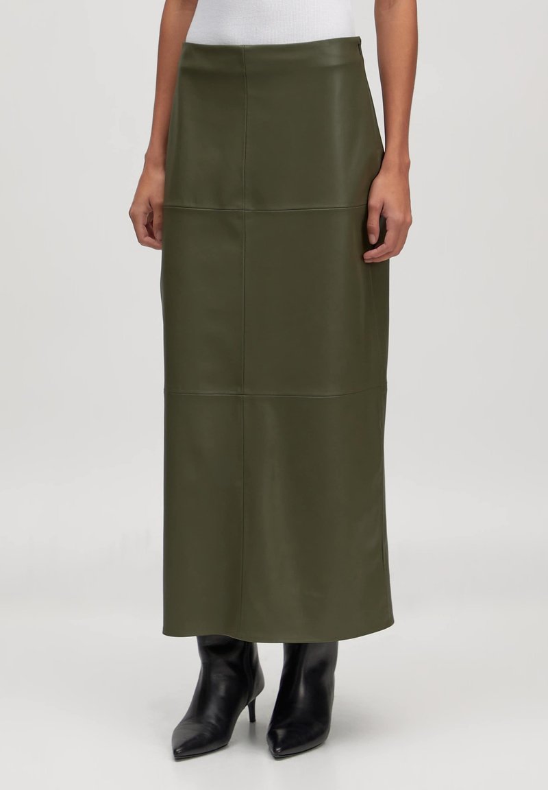 Olijf groene leren midi rok met een gladde textuur, voorzien van verticale naaddetails en een rechte silhouet, gecombineerd met zwarte stilettoboots.