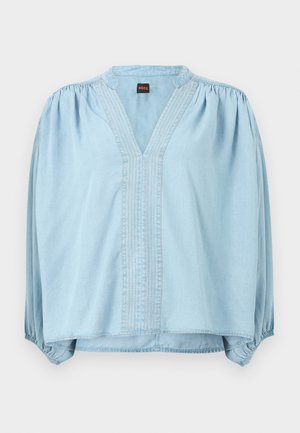 Svijetloplava bluza s dugim rukavima i V-izrezom, skupljenim ramenima, vertikalnim ukrasnim šavovima, elastičnim manžetama i malom oznakom Boss unutar ovratnika.