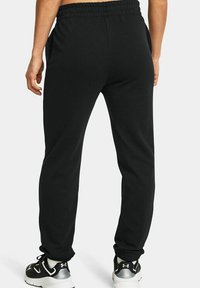 Schwarze Sweatpants aus weichem Stoff mit einer entspannten Passform. Verfügt über einen elastischen Bund, zwei seitliche Taschen und Bündchen an den Knöcheln.