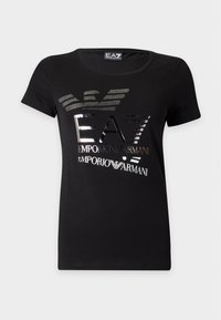 Μαύρο κοντομάνικο t-shirt με μεταλλικό ασημένιο λογότυπο EA7 Emporio Armani και στυλιζαρισμένο σχέδιο αετού στο μπροστινό μέρος.