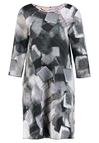 Vestido de patrón en blanco y negro con mangas de tres cuartos, que presenta texturas y formas abstractas. Hecho de tejido ligero.