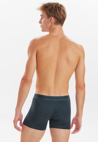 Sorte mønstrede boxershorts med en blød talje. Stofmet har en glat tekstur, der præsenterer et geometrisk design og en tætsiddende form.