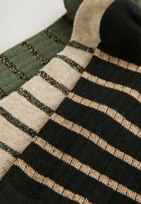 Three pairs of socks featuring green, beige, and black colors with horizontal stripes and metallic thread accents for added texture.