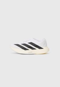 White running shoe with black stripes and cream sole, viewed from the side on a plain light background.