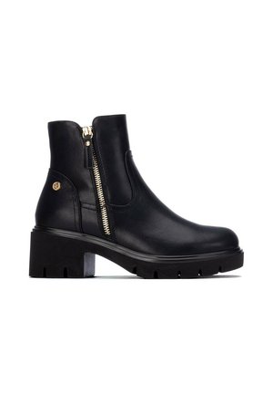 Stivaletto nero con tacco spesso, cerniera laterale e un piccolo emblema dorato vicino al tallone su sfondo bianco.