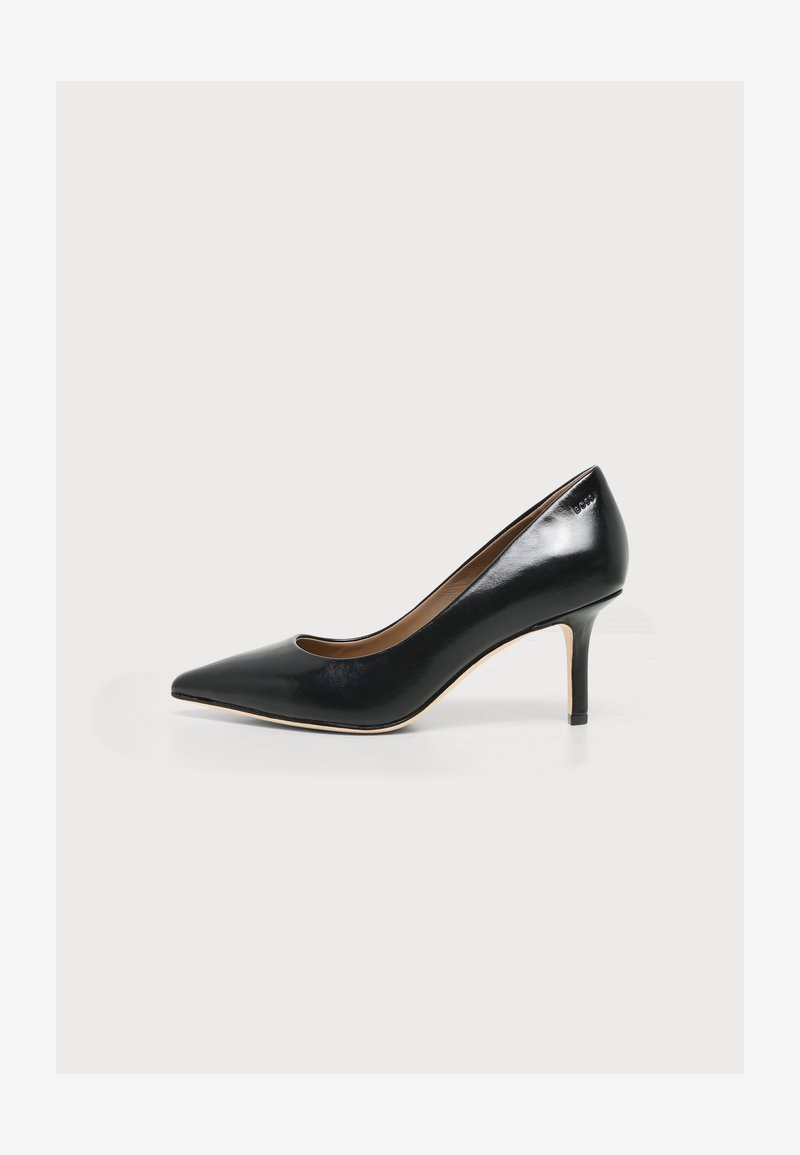 Escarpin en cuir noir à talon haut, bout pointu et talon fin, vu de profil sur fond blanc.