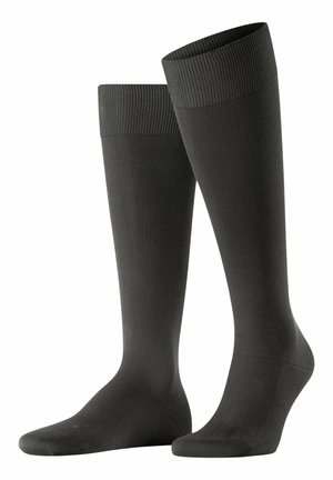 Calzini neri fino al ginocchio con una texture a coste, bordo elastico e parte superiore liscia, progettati per comfort e supporto.