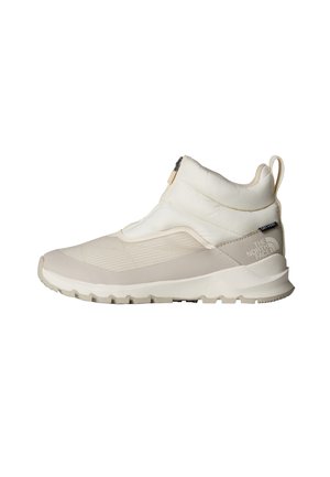 Botas de tobillo beige claro con parte superior acolchada, textura suave, suela de goma gris y cierre de cremallera lateral con marca en el talón.