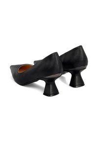 Zapatos de tacón alto de cuero negro con punta afilada y un diseño de tacón acampanado único. Textura suave con un acabado brillante en el acento del tacón.