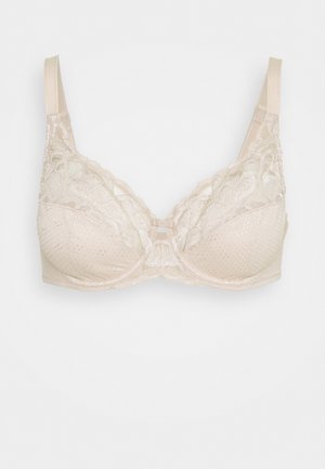 Soutien-gorge en dentelle beige avec des bonnets rembourrés, orné d'un motif texturé et d'accents floraux. Bretelles réglables et détail en nœud central.