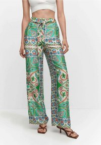 Pantalon fluide à motifs verts, blancs et bleus avec des dessins floraux. Fabriqué en tissu léger, doté d'une taille avec cordon de serrage et de jambes larges.