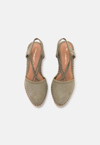 Olivově zelené semišové šlapky na podpatku s křížovým páskovým designem, kulatou špičkou a prošívaným jutu obšitím. Kožená stélka, velikost 37.