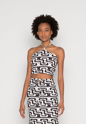 Top cropped halter em padrão preto e branco com um design ajustado. O tecido apresenta um motivo geométrico. Saia de cintura alta a condizer, com detalhe de laço.
