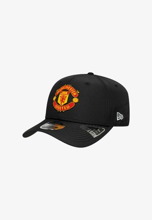 Schwarze Baseballkappe mit Manchester United-Emblem auf der Vorderseite, verstellbarem Riemen auf der Rückseite und New Era-Logo an der Seite.