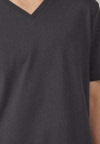 T-shirt z dekoltem w serek w ciemnoszarym kolorze, wykonany z bawełny, z subtelnym logo na piersi, krótkimi rękawami oraz miękką, gładką fakturą.