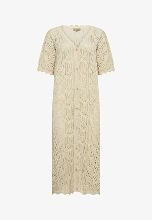 Jasnobeżowy kardigan dziany z krótkimi rękawami, z falbaniastym dekoltem oraz skomplikowanym otwartym wzorem liści, zapinany na guziki.