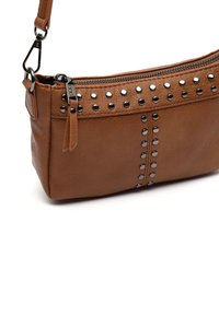 Borsa a mano in pelle marrone con borchie argentate lungo la parte anteriore, chiusura con zip sulla parte superiore e tracolla rimovibile. Texture liscia, forma rettangolare.