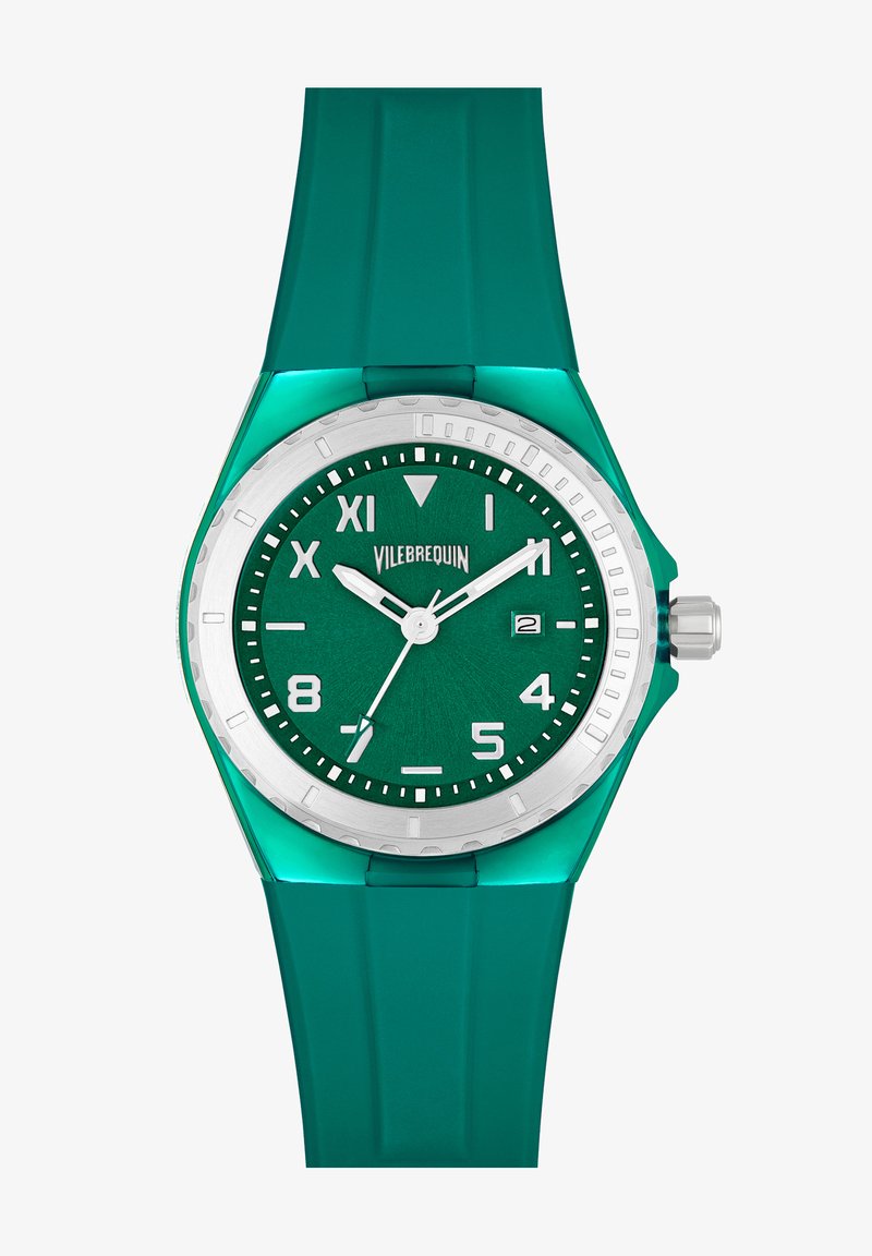 Zaļš silikona rokas pulkstenis ar tekstētu zaļu ciparnīcu, sudraba rāmi un baltām stundu atzīmēm. Ievērojams ar datuma rādītāju un apaļu korpusa formu.