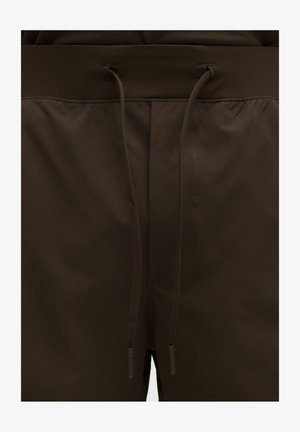 Bruine atletische shorts met een tailleband met trekkoord, voorzien van een gladde textuur en minimale stiksel details. Geschikt voor sportieve activiteiten.