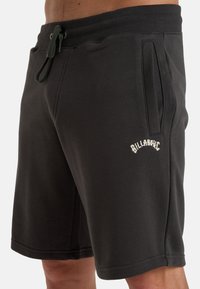 Donkergrijze shorts gemaakt van een zachte stof. Voorzien van een trekkoord in de taille, zijzakken en een geborduurd logo op het been.