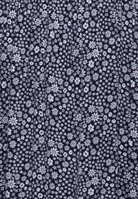 Laine navy avec un motif floral blanc comportant différentes tailles de fleurs, réparties uniformément sur la surface, créant une apparence texturée.