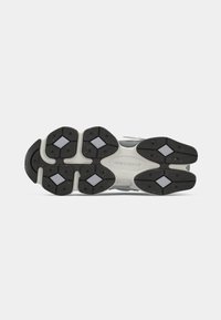 Athletikschuh-Außensohle aus grauem und schwarzem Gummi mit multidirektionalem Traktionsmuster. Verfügt über hellgraue Akzente und Logodetails.