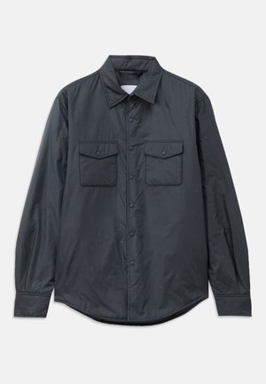 Camisa de manga larga gris oscuro hecha de tela suave, con cuello puntiagudo, dos bolsillos en el pecho y cierre de botones en la parte delantera.