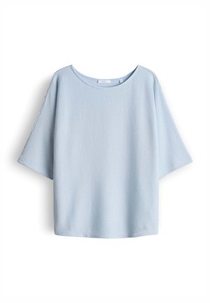 Maglietta a maniche corte in maglia azzurro chiaro con maniche larghe e scollatura rotonda, distesa su uno sfondo bianco.