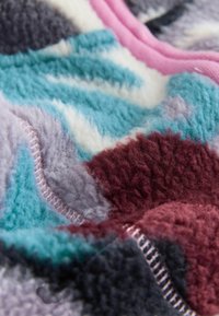 Material moale din fleece cu un model abstract multicolor în nuanțe de teal, marsala, gri, alb și detalii cusute roz.