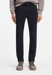 Μπλε ναυτικό παντελόνι από βαμβακερό μείγμα με ίσια γραμμή, διαθέτει μπροστινές τσέπες και κλείσιμο με κουμπί, συνδυασμένο με καφέ αθλητικά παπούτσια.