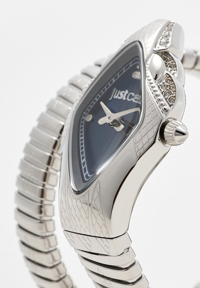 Montre argentée avec un boîtier triangulaire, des accents texturés, un cadran bleu, des aiguilles argentées et un bracelet métallique flexible avec des maillons polis.