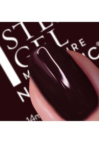 Donker bordeauxrode gelnagellak op een gepolijste nagel, met een glanzende afwerking en een soepele textuur, met branding zichtbaar op de achtergrond.