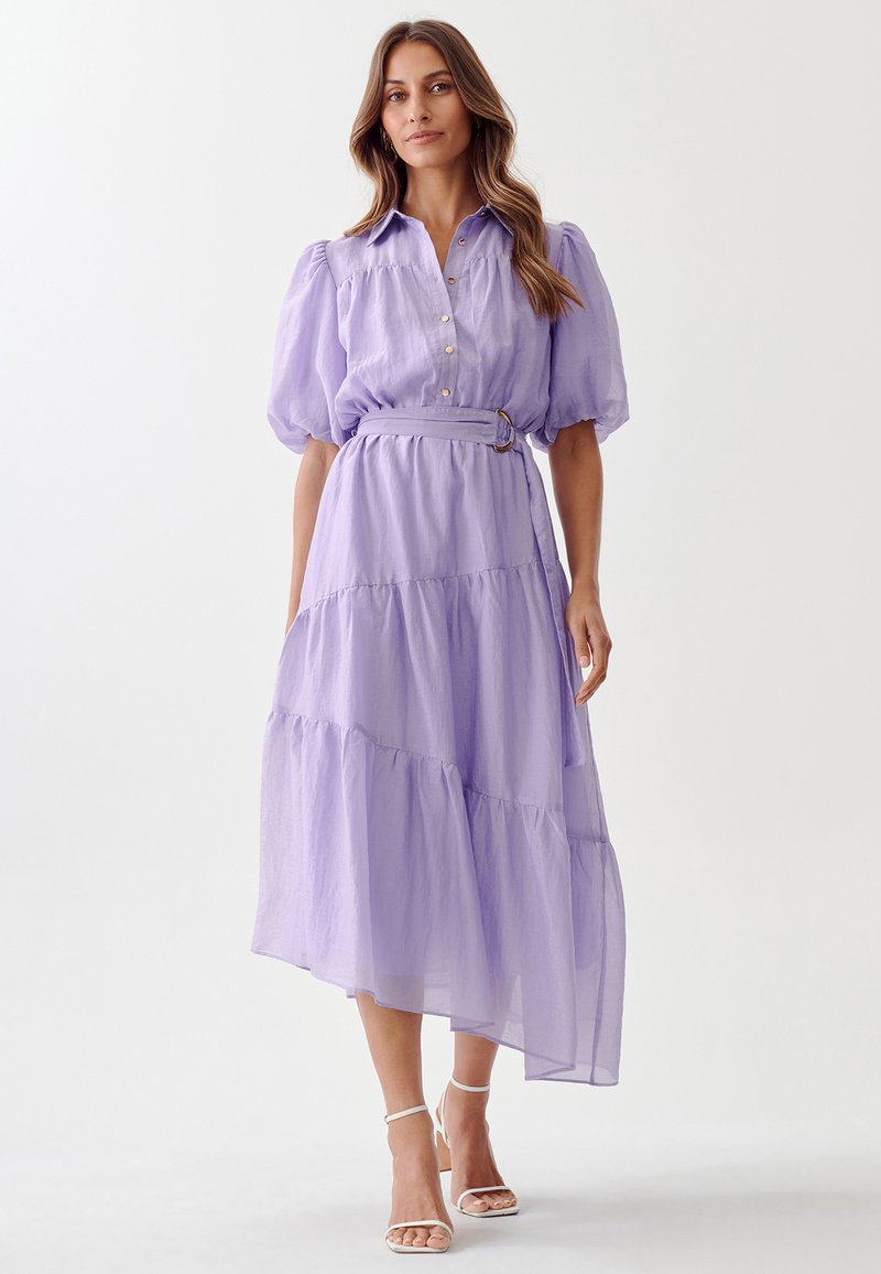 Lavender tiered maxi dress with short puff sleeves, button-front, belt at the waist, and a lightweight, textured fabric.