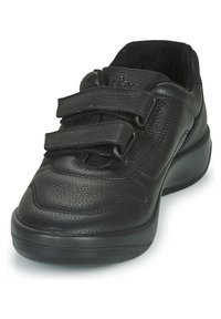 Baskets en cuir noir avec un bout rond, deux sangles Velcro et une surface texturée. Semelle rembourrée pour un confort accru.