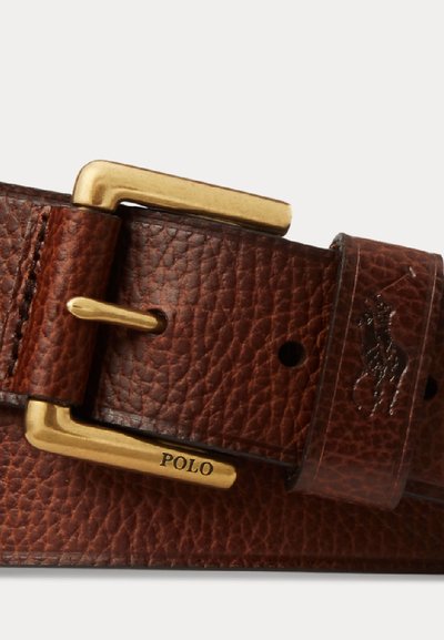 Cintura marrone in pelle texturizzata con fibbia rettangolare dorata incisa con la scritta "POLO" e logo del giocatore di polo in rilievo sul passante della cintura.