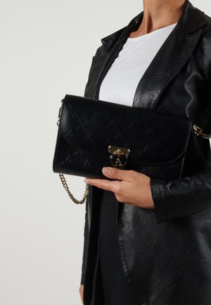 Schwarze Leder-Crossbody-Handtasche mit gestepptem Muster, goldenen Beschlägen und Kettenriemen. Vorderklappe mit Herz-Akzent.