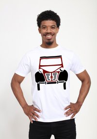 Bílý tričko s grafickým potiskem vintage auta v červené a černé barvě, s výraznými světlomety a detailním designem mřížky.