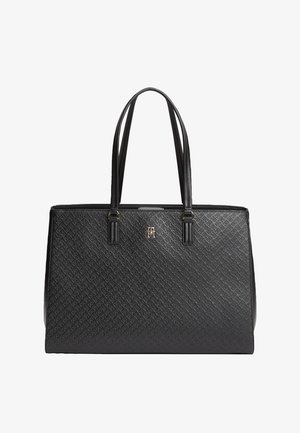 Sort textured shoppingtaske med dobbelte skulderremme og guld metal logoemblem centreret på frontpanelet.