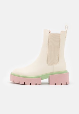 Bottine crème avec panneau latéral élastique, semelle intermédiaire plateforme verte et semelle extérieure rose épaisse à crampons.