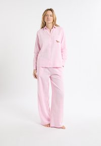 Różowy zestaw piżam w kratę, składający się z koszuli na guziki z długim rękawem, kieszenią na piersi i haftowanym wzorem psa, w komplecie z szerokimi spodniami.