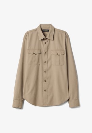 Camicia beige a maniche lunghe con bottoni, due tasche sul petto con pattine e bottoni e colletto a punta, etichettata "PIOMBO" all'interno del colletto.