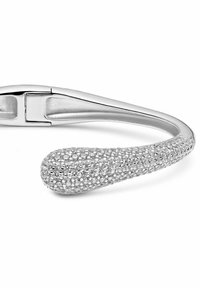 Bracciale d'argento con una fascia liscia e un'estremità affusolata texturizzata, arricchita da cristalli, che offre un dettaglio scintillante.