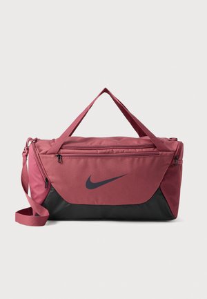 Sac de sport Nike rose et noir avec des poignées supérieures, une bandoulière, des compartiments zippés et une poche latérale en mesh.