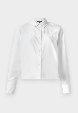 Fehér, hosszú ujjú ing, klasszikus gallérral, két mellzsebbel és rövidített fazonnal. Simább pamut anyag.