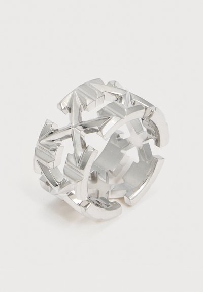 Ευρεία ασημένια βέρα με διαπλεκόμενα βέλη που σχηματίζουν ένα γεωμετρικό, διακοσμητικό σχέδιο γύρω από τη στεφάνη.