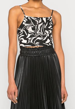 Haut abstrait noir et blanc recadré avec fines bretelles, assorti d'une jupe plissée en similicuir noir taille haute.